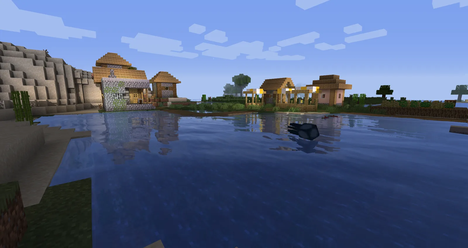 Sildur's Enhanced Default shaders: a village by a lake with soft shadows and clear water